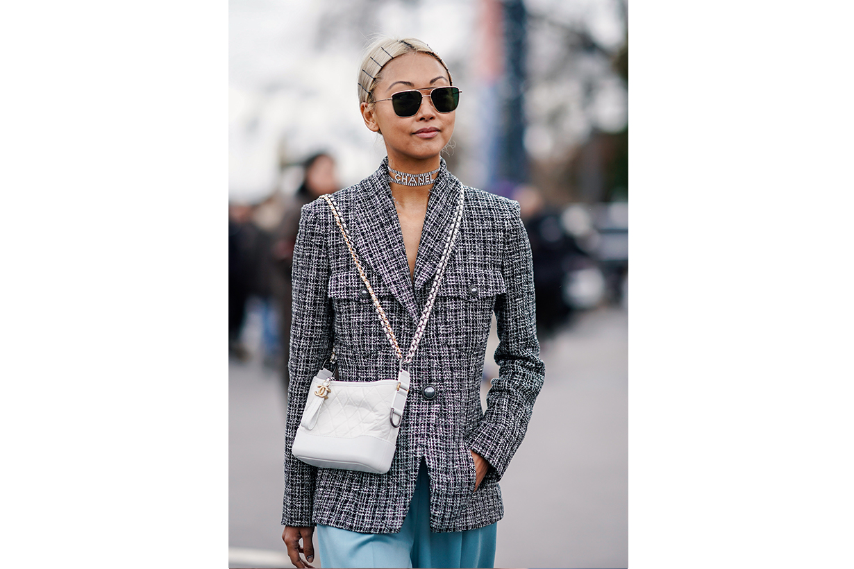  Vanessa Hong wears a gray checked blazer jacket, a white Chanel bag, sunglasses, a Chanel choker, hair brooches, outside Chanel, during Paris Fashion Week Womenswear Fall/Winter 2019/2020, on March 05, 2019 in Paris, France. 